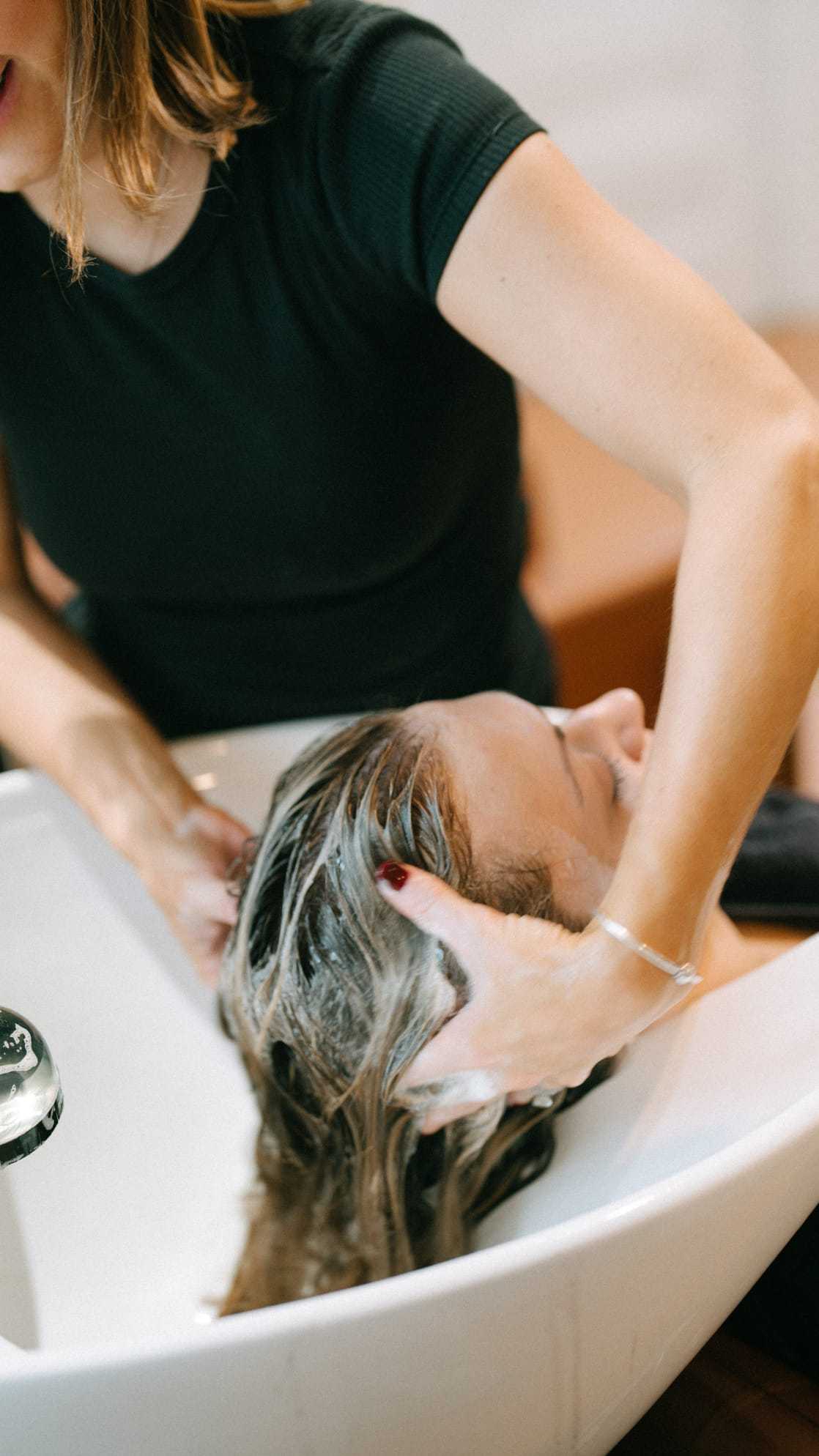 Woman receiving a hair wash at a salon sink.